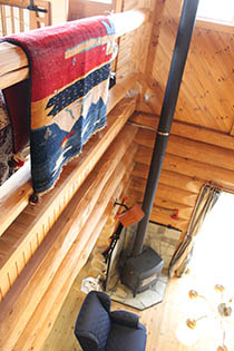 モデルハウス内部　2回から見下ろすリビングの薪ストーブの写真